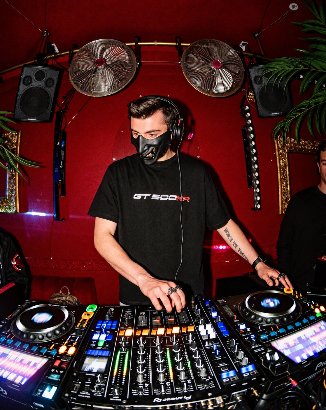 GR3GOR mixing in a red room with headphones and black mask